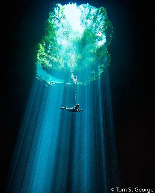 Buzo nadando en medio de un haz de luz en Cenote Maravilla.