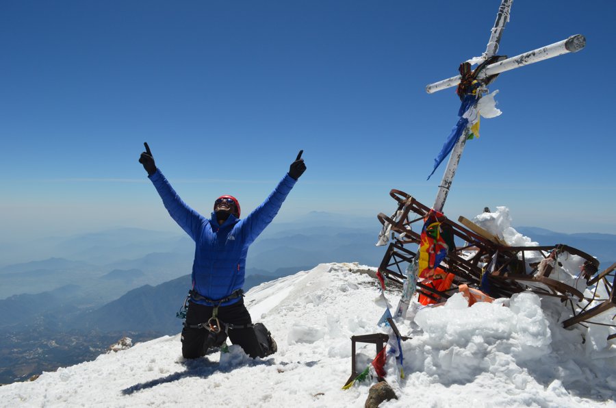 Montañista celebrando su llegada a cumbre.