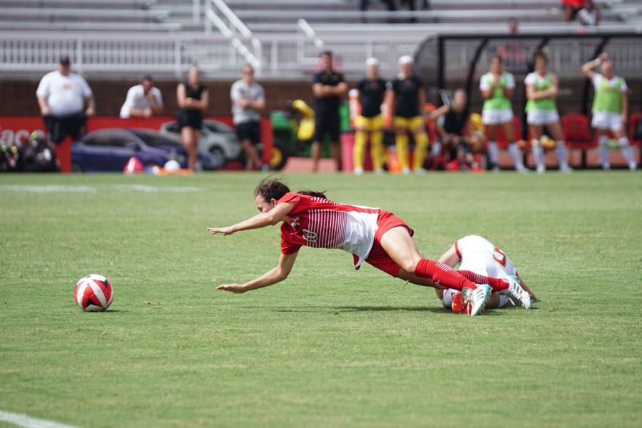 Mujer cayendo en entrenamiento de fútbol.