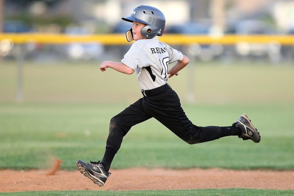 Niño corriendo para ocupar las bases según las reglas del béisbol