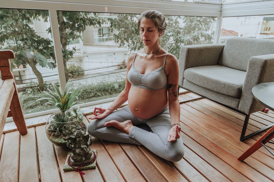 Mujer meditando y practicando yoga en el embarazo