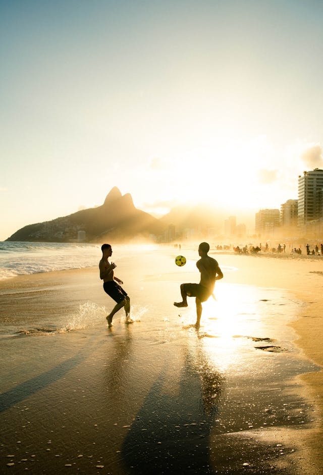 Niños jugando fútbol en la playa