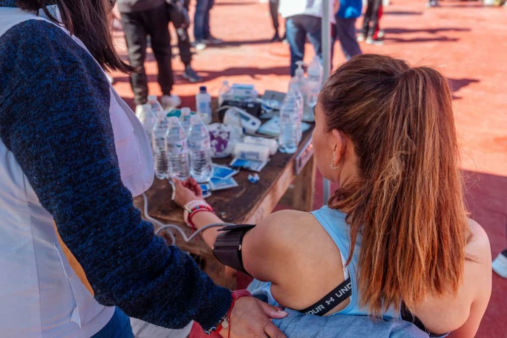 Médico del deporte revisando a una atleta.